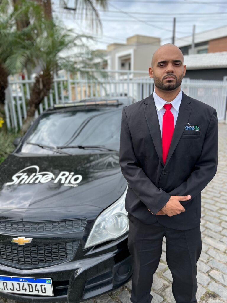 Colaborador da Shine Rio ao lado de veículo da empresa